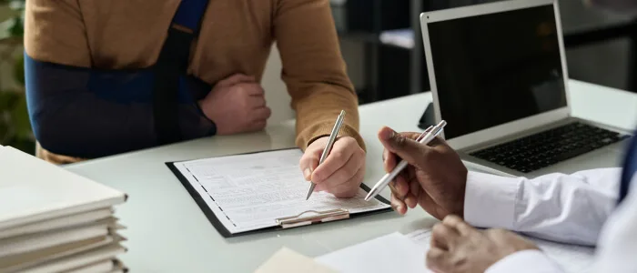 A person signs documents after being injured on another person's property