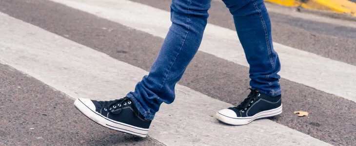 Young pedestrian crossing a busy intersection