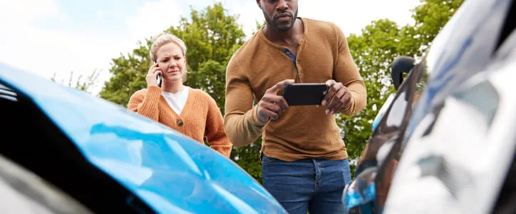 Man taking picture of his car after accident
