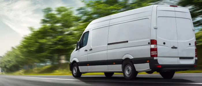 A deliver van speeds down the road