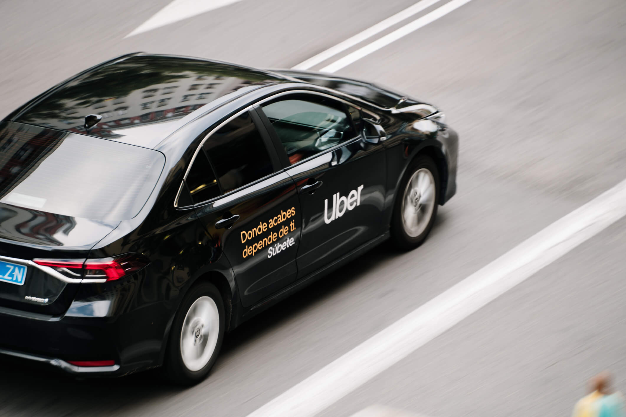 Uber driving down the road