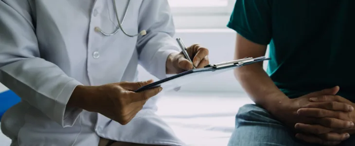 Male patient having consultation with doctor or psychiatrist who working on diagnostic examination on men's health disease or mental illness in medical clinic or hospital mental health service center